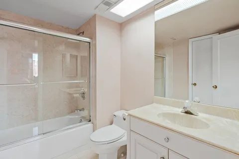 a bathroom with a granite countertop sink toilet and shower