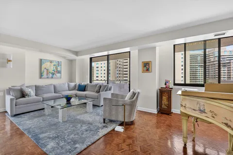 a living room with furniture and large windows