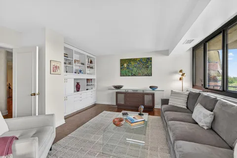 a living room with furniture and a book shelf