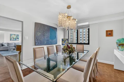 a view of a dining room with furniture a chandelier and wooden floor