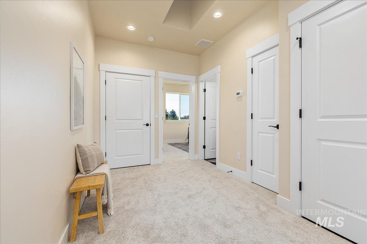 1433 North Bluffs Ridge Lane Boise, ID 83704 - Photo 8 of 18 Corridor with light carpet and recessed lighting