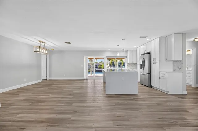 a kitchen with kitchen island granite countertop a sink cabinets and stainless steel appliances