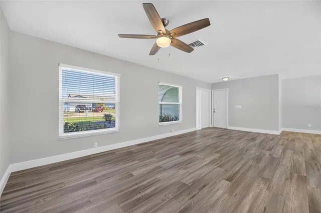 a view of empty room with wooden floor