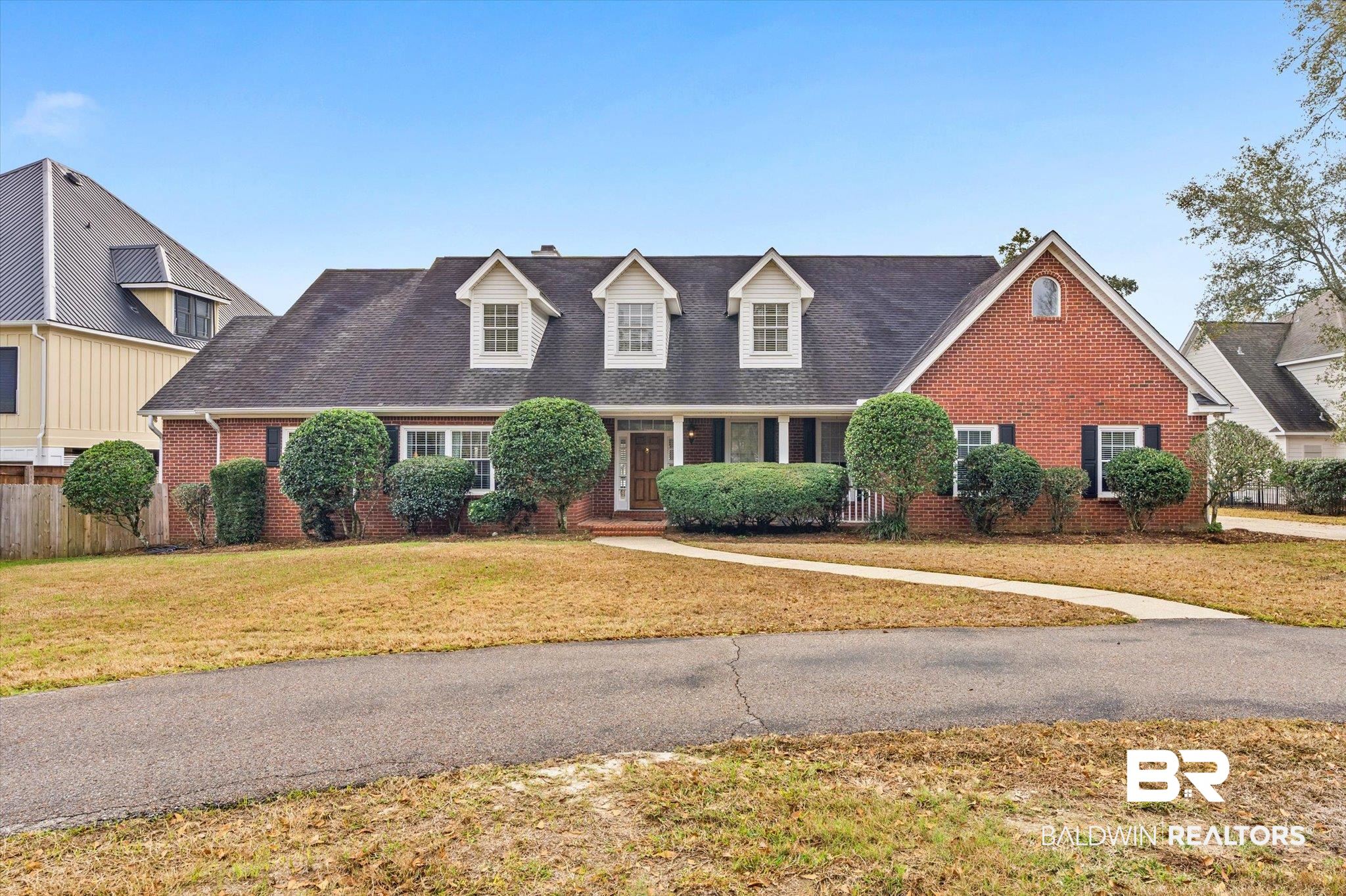 Cape cod-style house with brick siding and a shingled roof
