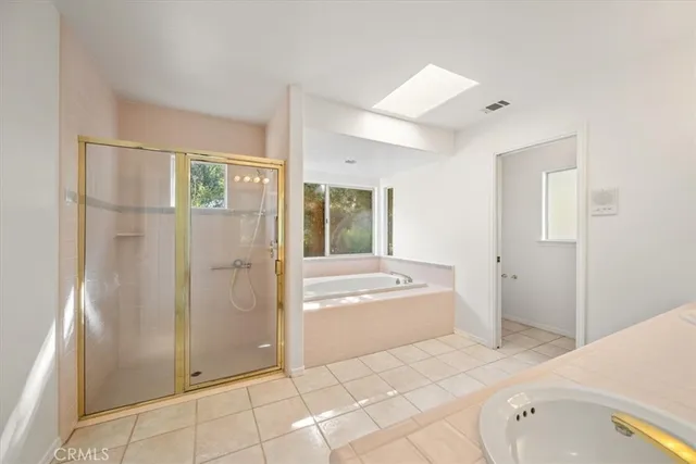 a spacious bathroom with a tub sink and mirror