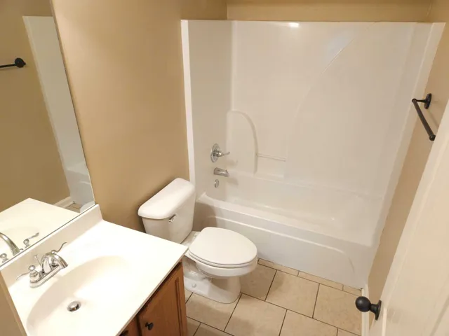 a white toilet sitting next to a bathroom sink and vanity
