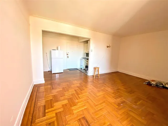 a view of empty room with wooden floor