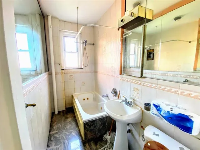 a bathroom with a sink mirror toilet and bathtub