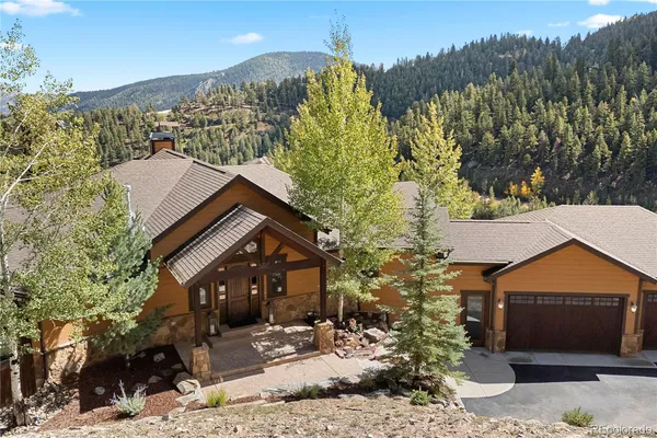 a front view of a house with a yard and mountain view in back