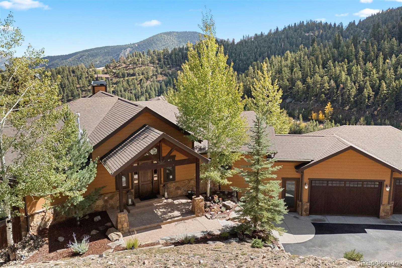 610 Clear Creek Road Evergreen, CO 80439 - Photo 2 of 50 a front view of a house with a yard and mountain view in back