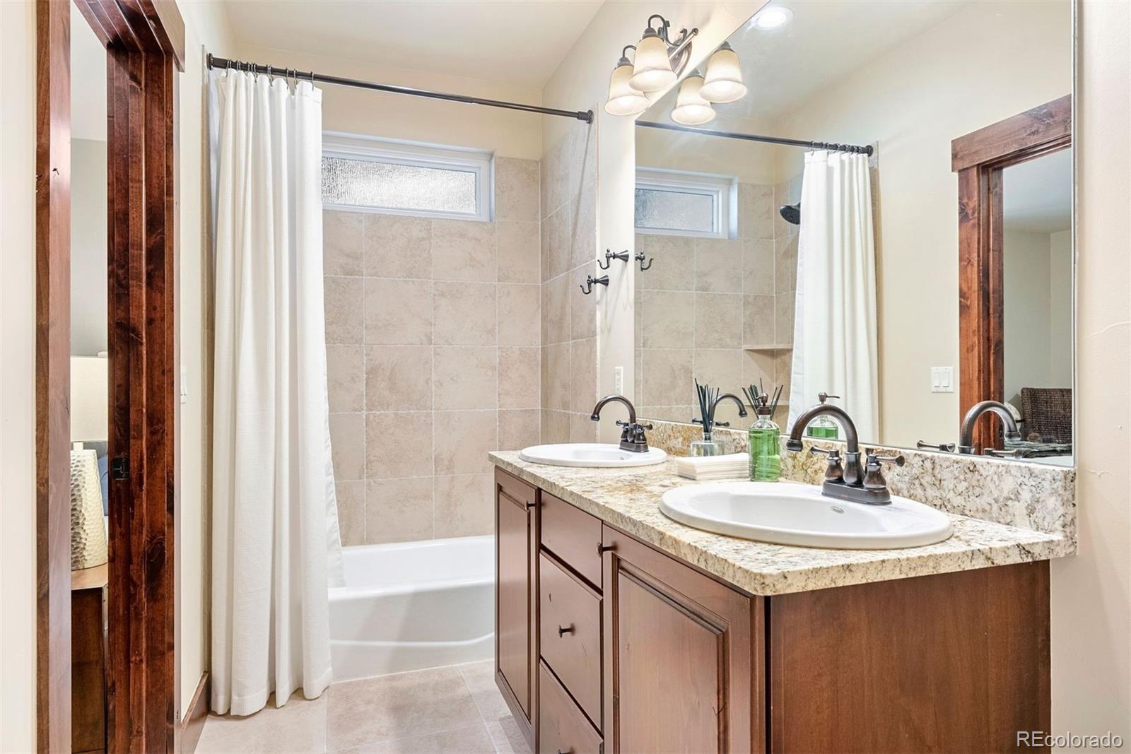 610 Clear Creek Road Evergreen, CO 80439 - Photo 26 of 50 a bathroom with a sink double vanity and a mirror