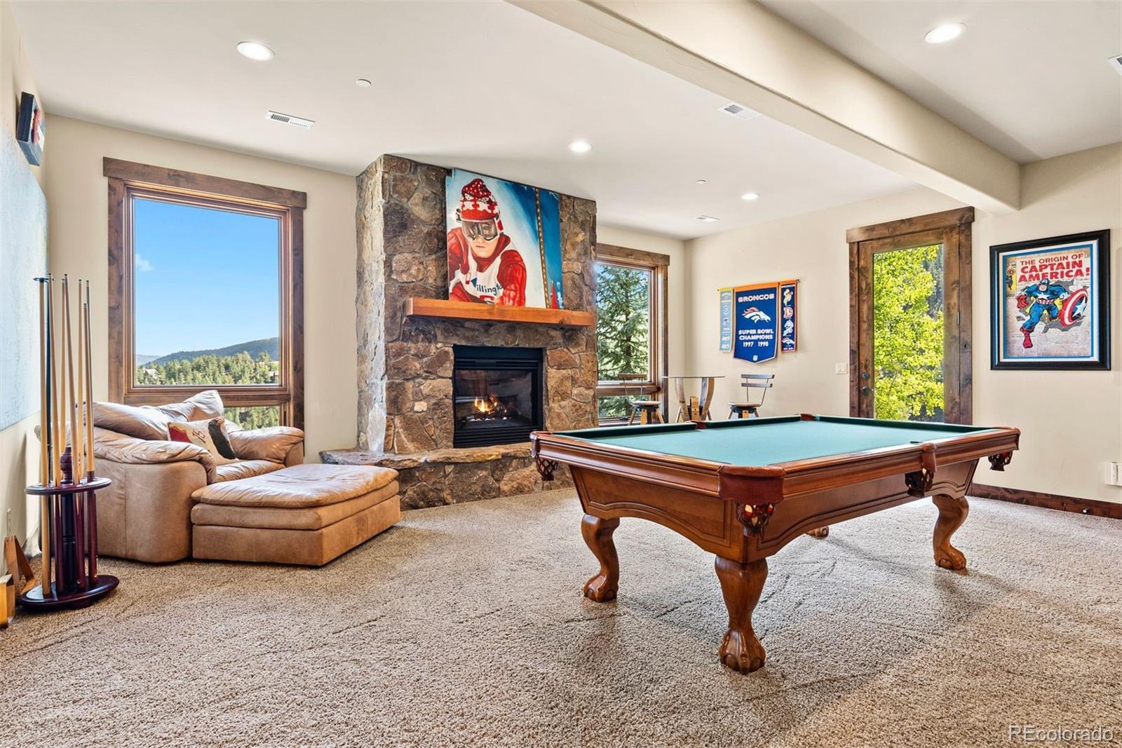 610 Clear Creek Road Evergreen, CO 80439 - Photo 29 of 50 a living room with furniture pool table flat screen tv and a fireplace