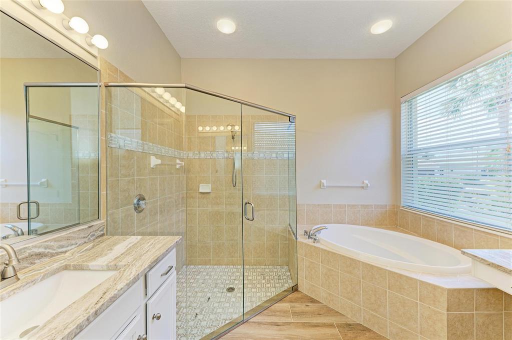 8772 Stone Harbour Loop Bradenton, FL 34212 - Photo 27 of 69 a spacious bathroom with a granite countertop sink a shower and a bathtub