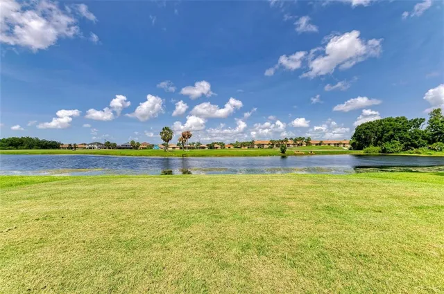 a view of a table and chairs in patio and a lake view