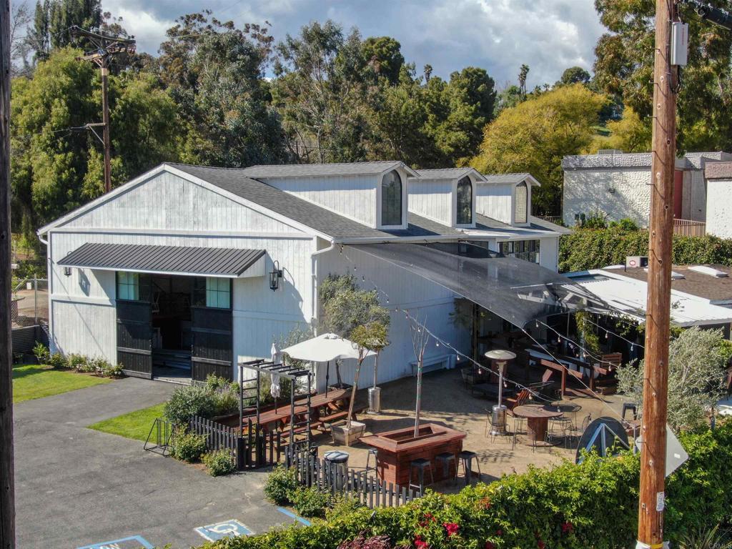 a backyard of a house with table and chairs under an umbrella