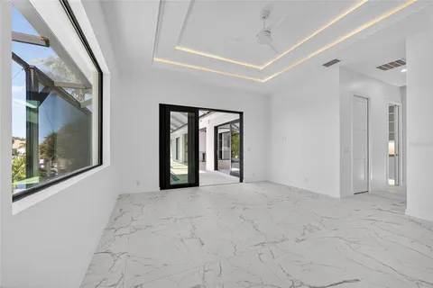 a view of an empty room with window and a kitchen