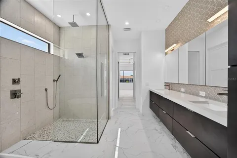 a bathroom with a double vanity sink a large mirror and shower
