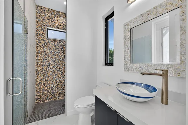 a bathroom with a sink a toilet and shower