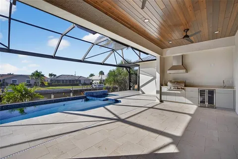 a view of a patio with a table and chairs under an umbrella with a small yard