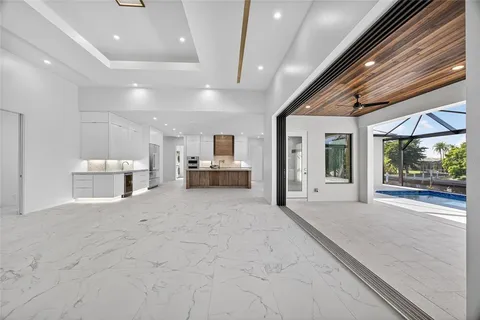 a large hall with stainless steel appliances kitchen island granite countertop a large window