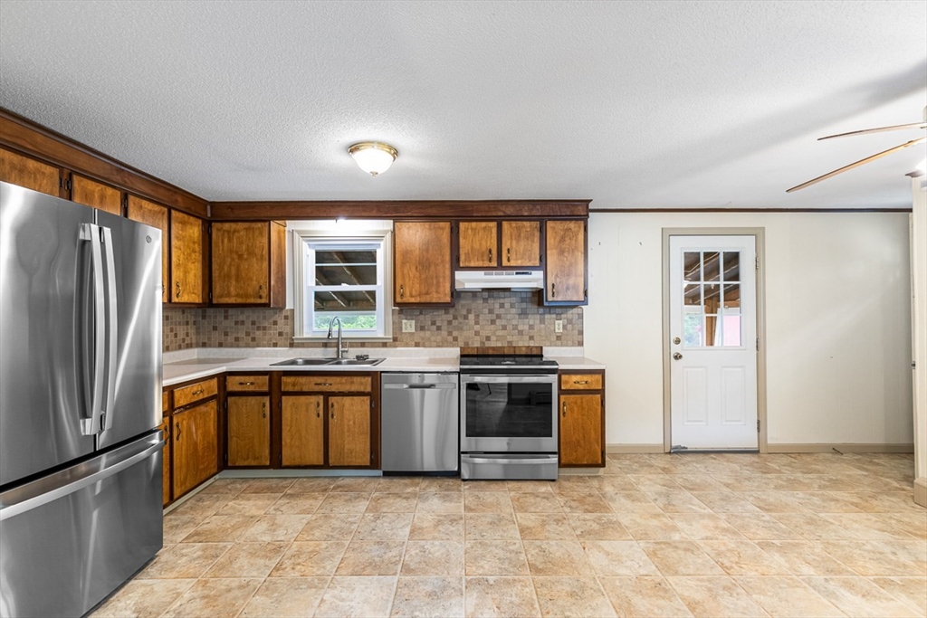 99 Swansom Road Swansea, MA 02777 - Photo 10 of 42 a large kitchen with stainless steel appliances granite countertop a stove sink and refrigerator