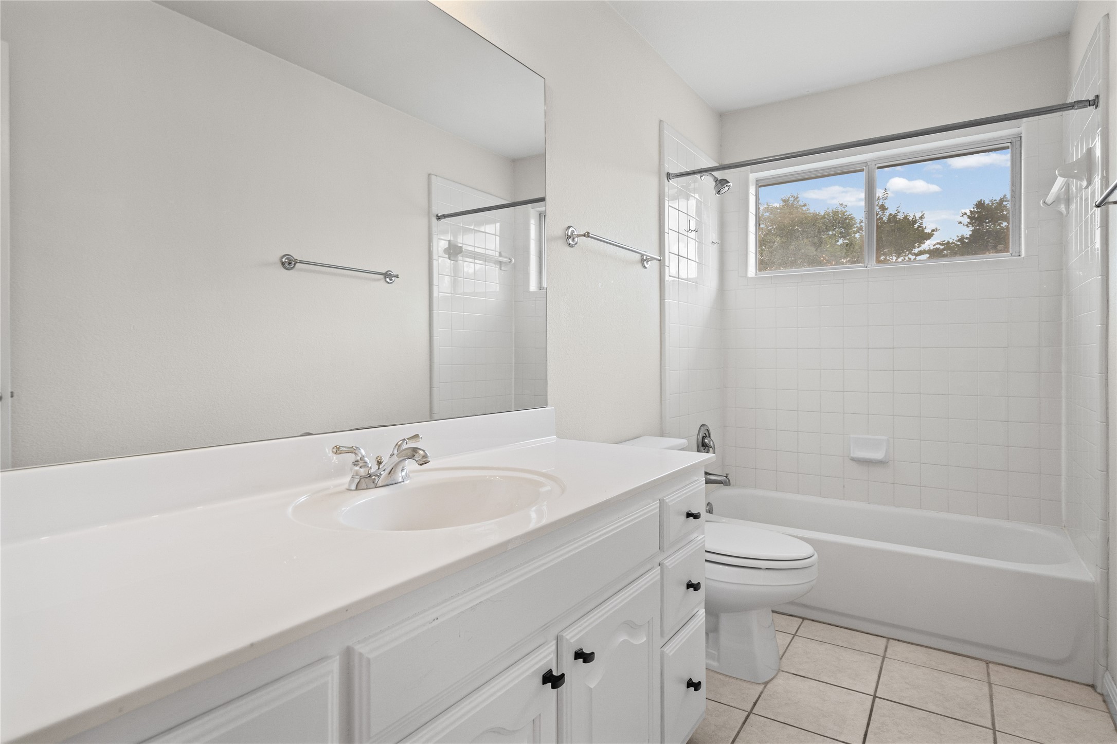 10700 Pointe View Drive Austin, TX 78738 - Photo 27 of 35 A well-lit bathroom features a vanity with ample counter space and a full-sized bathtub with tiled walls.