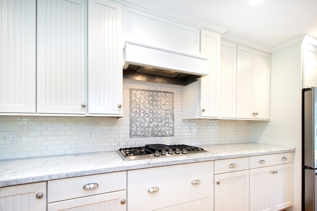 584 Hatherly Road Scituate, MA 02066 - Photo 11 of 42 a kitchen with a stove and white cabinets