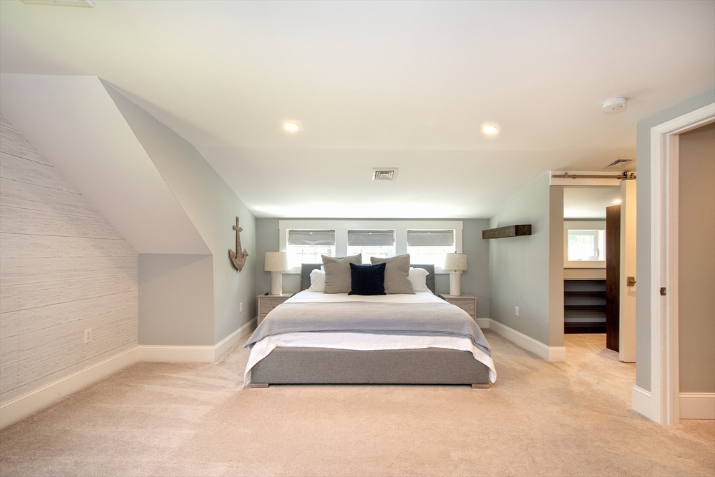 584 Hatherly Road Scituate, MA 02066 - Photo 28 of 42 a bedroom with a large bed and chandelier