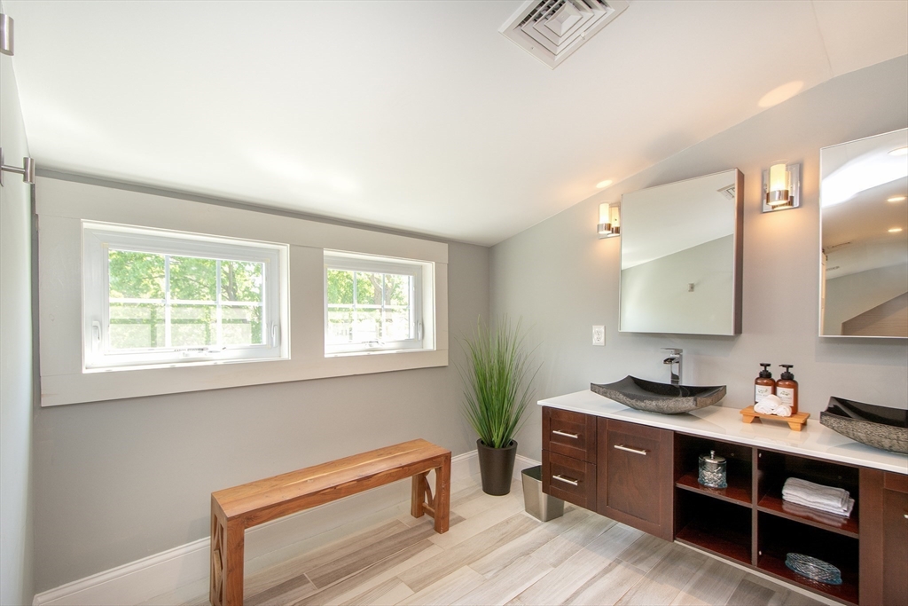 584 Hatherly Road Scituate, MA 02066 - Photo 31 of 42 a spacious bathroom with a granite countertop double vanity sink a mirror and a window