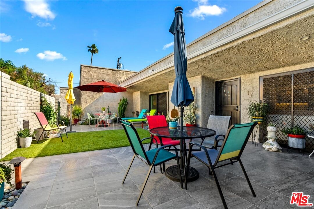 1111 East Ramon Road, Unit 17 Palm Springs, CA 92264 - Photo 16 of 34 a view of a patio with a table and chairs