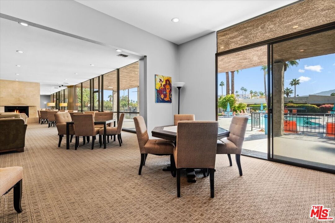 1111 East Ramon Road, Unit 17 Palm Springs, CA 92264 - Photo 30 of 34 a dining room with furniture and a floor to ceiling window