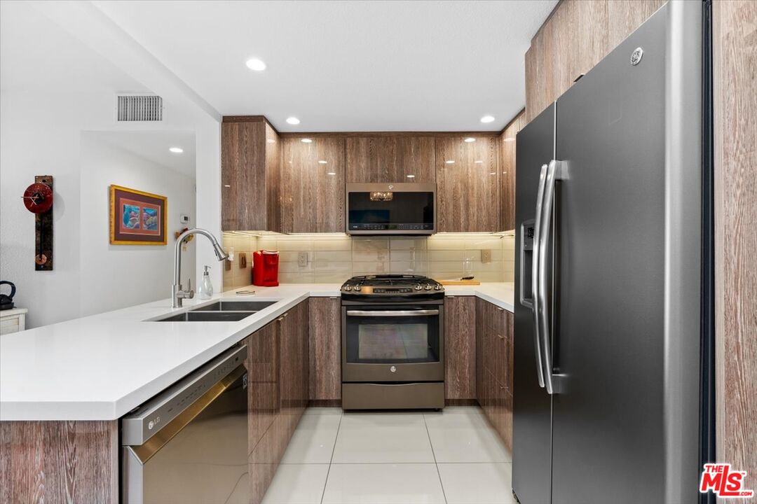 1111 East Ramon Road, Unit 17 Palm Springs, CA 92264 - Photo 5 of 34 a kitchen with stainless steel appliances granite countertop a sink stove and refrigerator