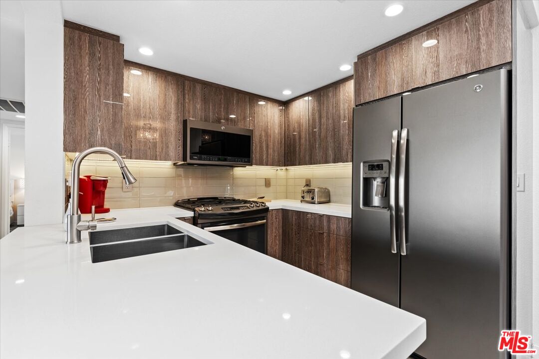 1111 East Ramon Road, Unit 17 Palm Springs, CA 92264 - Photo 6 of 34 a kitchen with a refrigerator and a stove top oven