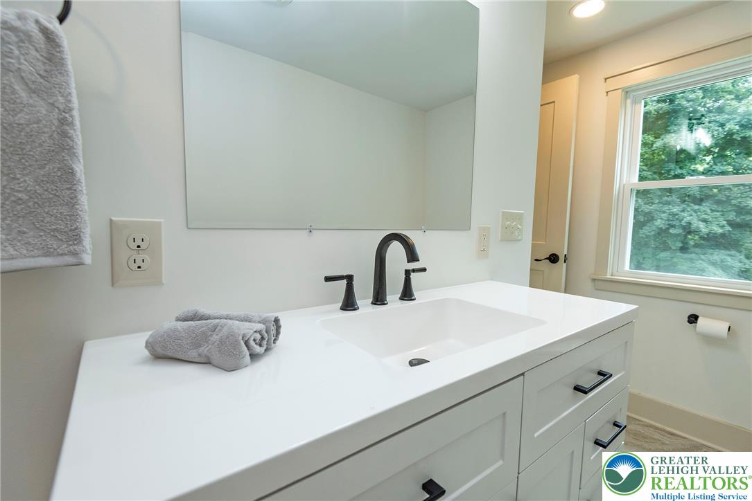 72 Allegheny Road Mount Bethel, PA 18343 - Photo 25 of 72 A well-appointed bathroom vanity with a clean white counter and modern fixtures, bathed in natural light.