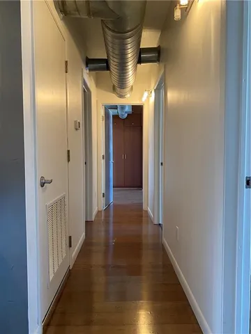 a view of a hallway with wooden floor