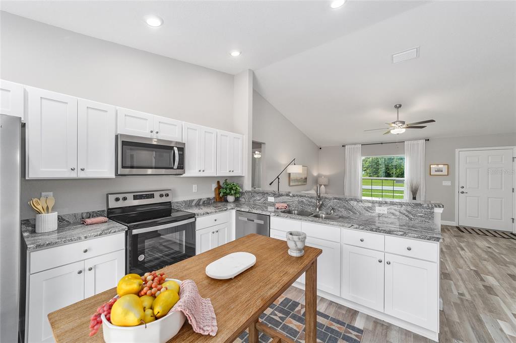 8571 Southwest 131st Place Ocala, FL 34473 - Photo 17 of 32 a kitchen with white cabinets appliances a sink and a window