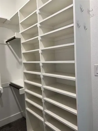 a view of walk in closet with empty racks