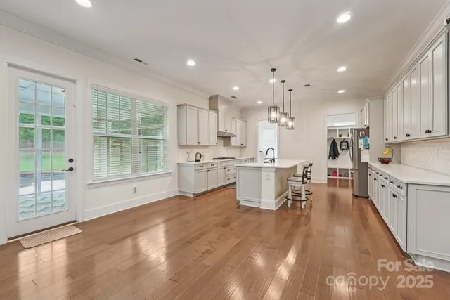 a large white kitchen with lots of counter space a sink and appliances