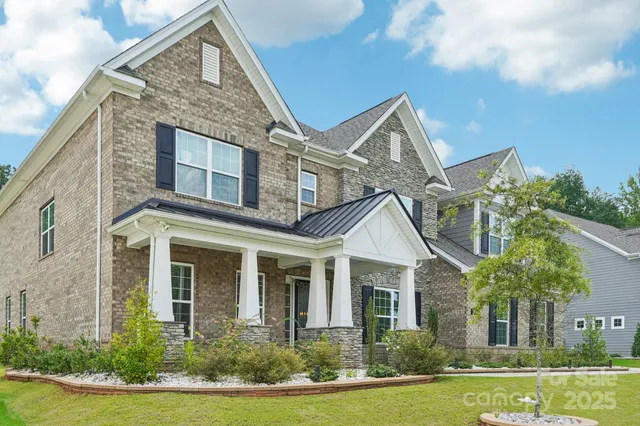 a front view of a house with a yard and trees
