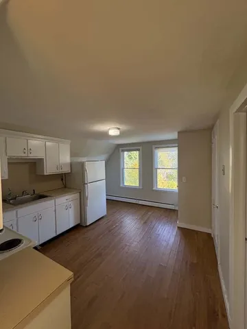 a large kitchen with a wooden floor and a sink