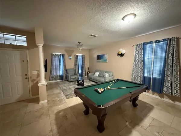 a room with pool table and windows