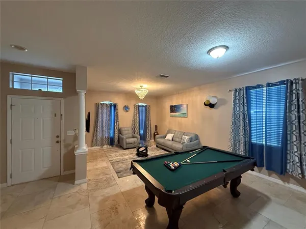 a room with pool table and windows
