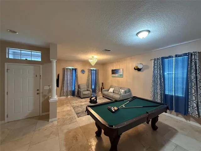 a room with pool table and windows