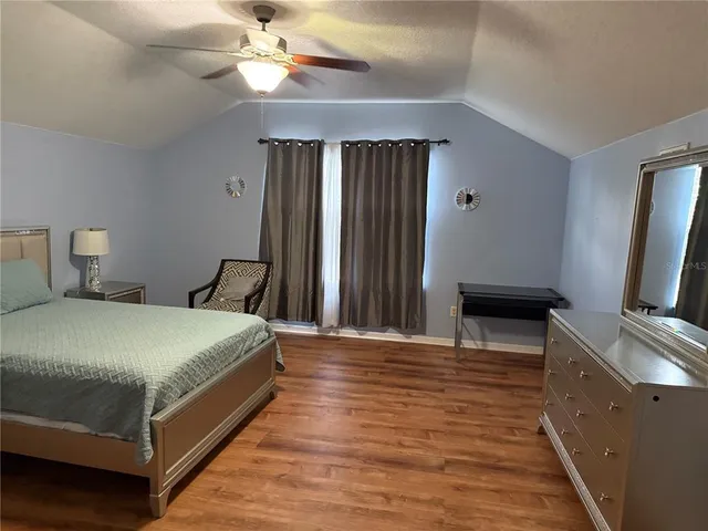 a bedroom with a bed and a flat tv screen on a dresser