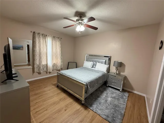 a bedroom with a bed and a flat tv screen on dresser