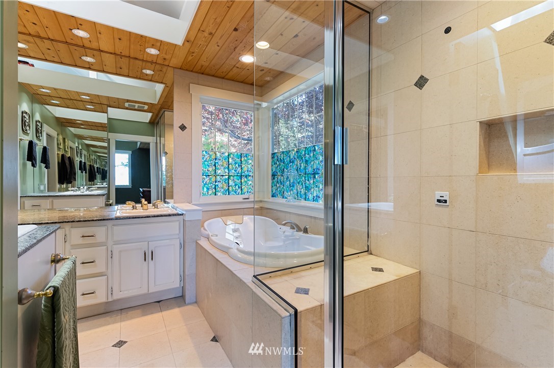 654 Clark Road Bellingham, WA 98225 - Photo 25 of 40 a spacious bathroom with a granite countertop sink and a mirror