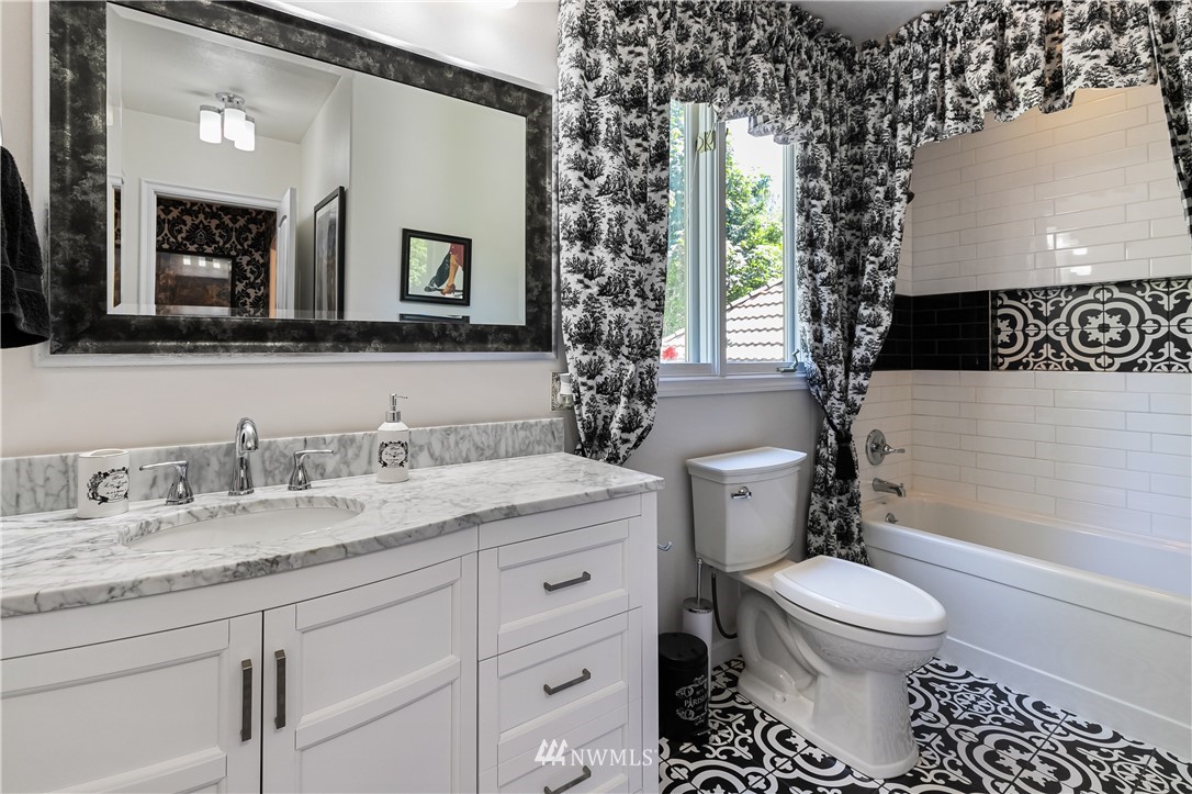 654 Clark Road Bellingham, WA 98225 - Photo 32 of 40 a bathroom with a granite countertop toilet a sink and a mirror