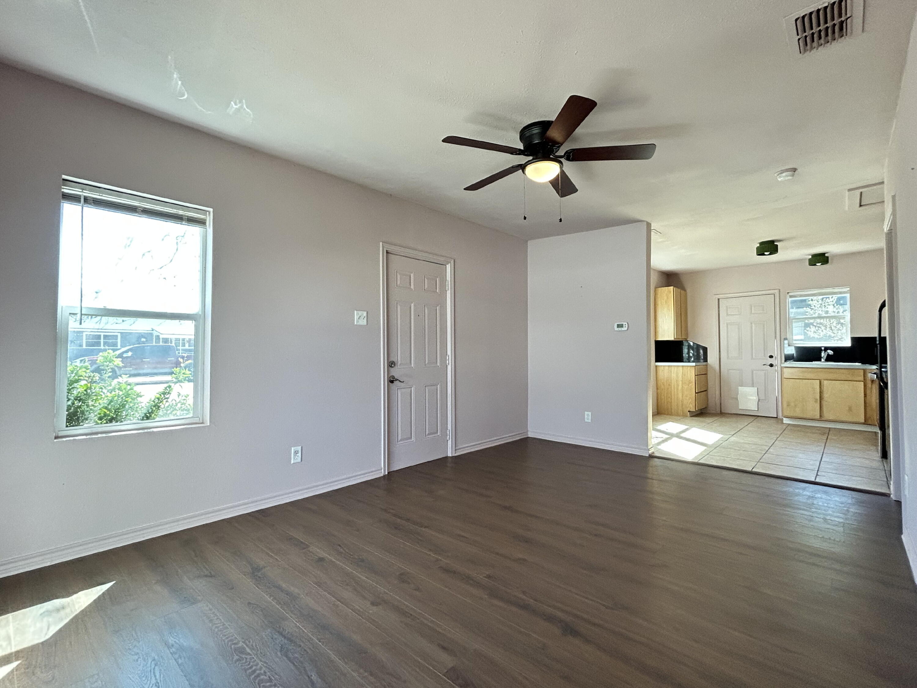 3118 37th Street, Unit FRONT Lubbock, TX 79413 - Photo 3 of 16 a view of an empty room with window and wooden floor