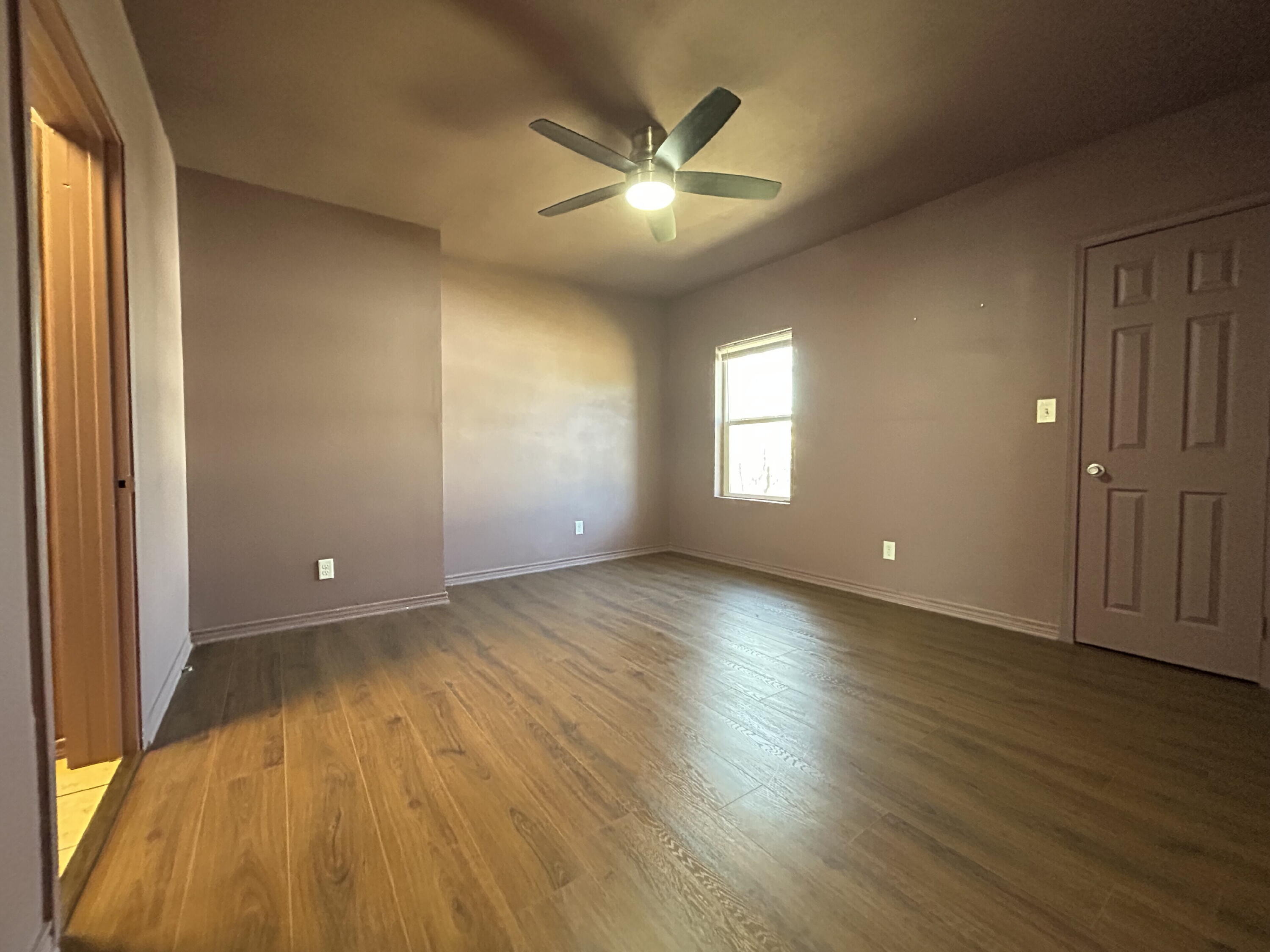 3118 37th Street, Unit FRONT Lubbock, TX 79413 - Photo 7 of 16 an empty room with wooden floor and windows