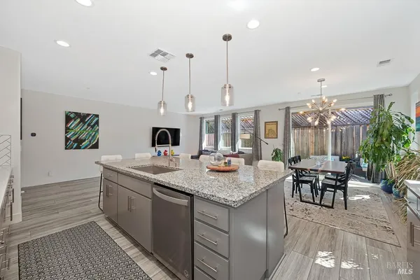 a view of kitchen island with stainless steel appliances granite countertop sink and stove